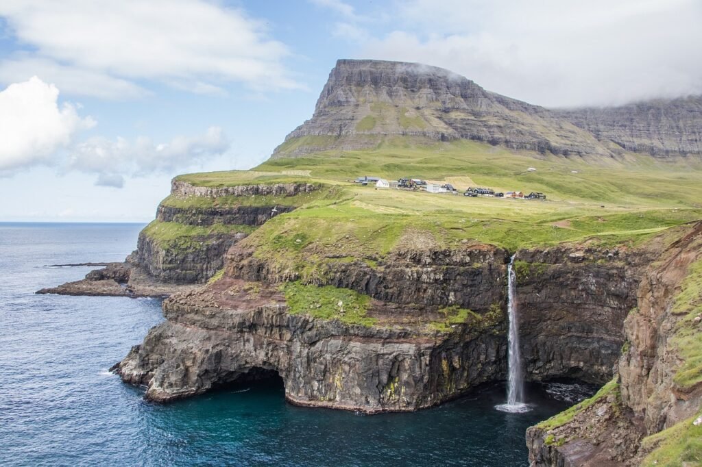 A shot of Múlafossur Waterfall from the cliffs